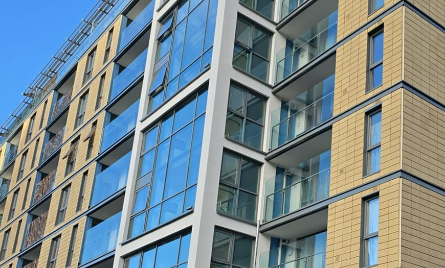 Close-up of the Whitgift Street residential façade in Croydon, showing glazed balconies, windows and external wall finishes.